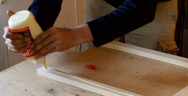 Applying wood glue to the pine strips