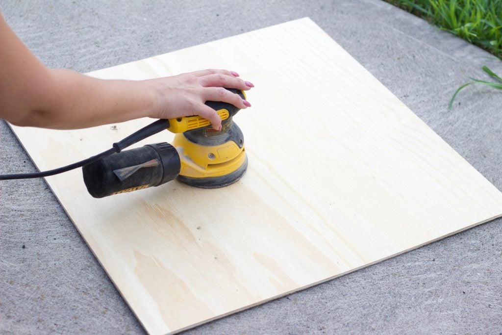Sand down the plywood board with a handheld sander