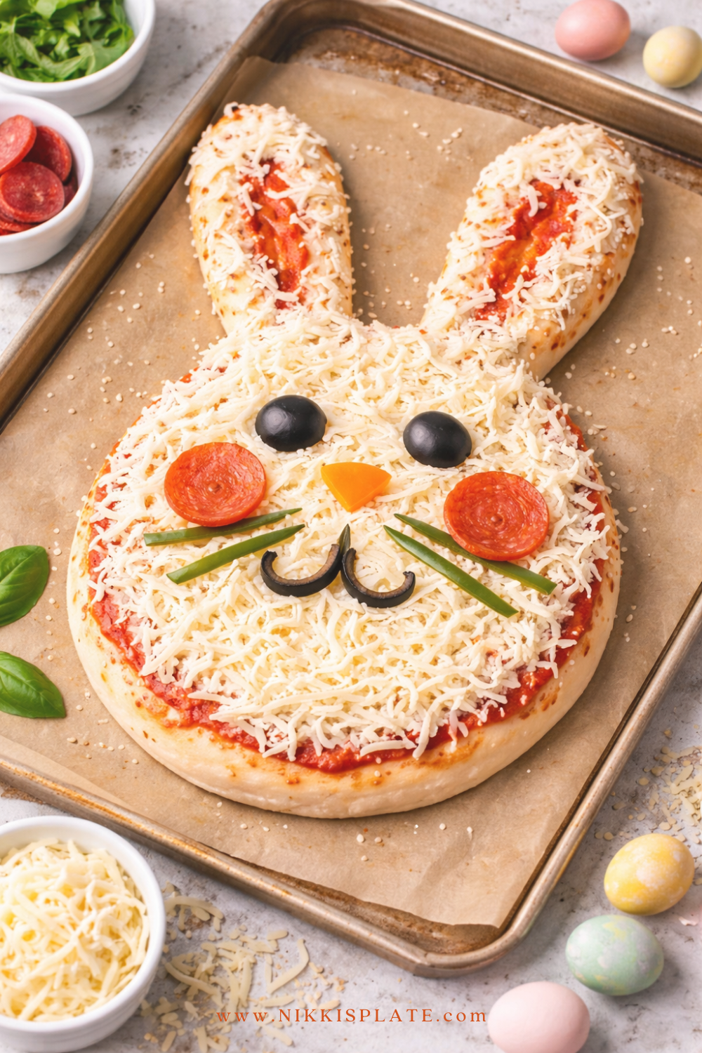 Homemade sourdough pizza shaped like a bunny with mozzarella, marinara sauce, and vegetable toppings on a baking tray