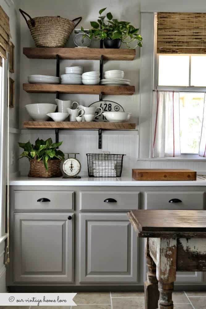 Tips for styling a farmhouse kitchen; grey cabinets, open shelving, wood in the kitchen, black kitchen hardware