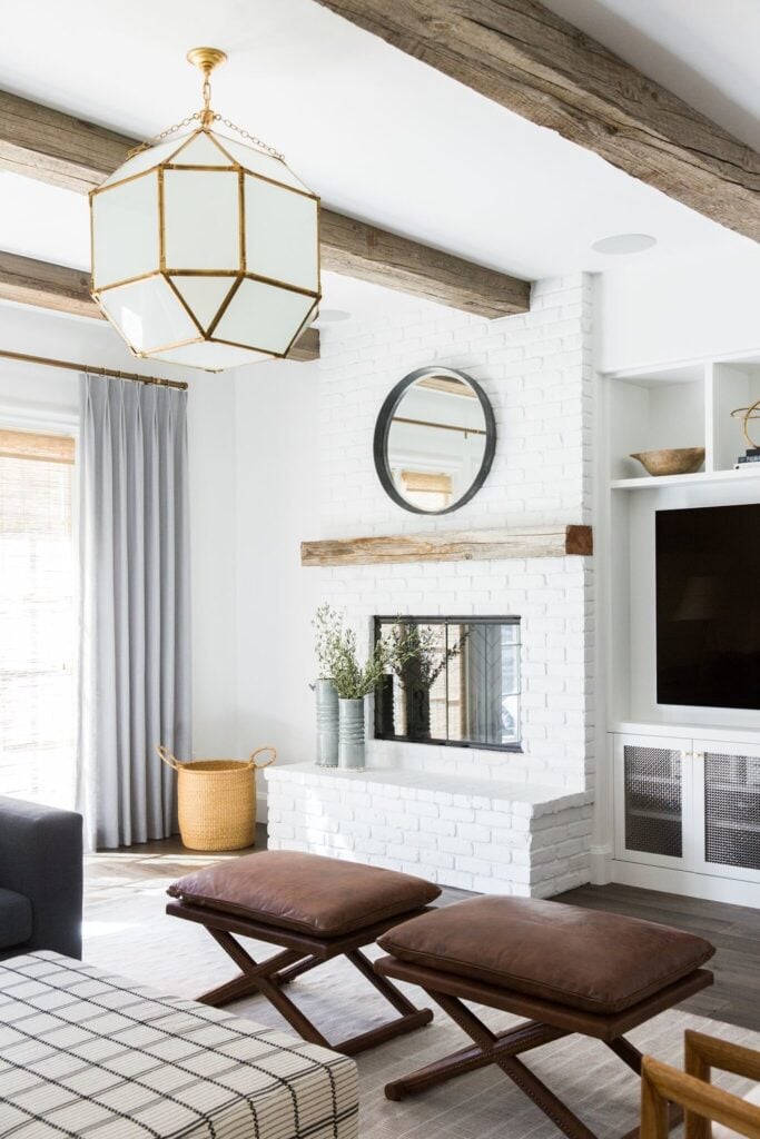 Studio Mcgee living room, white stone fireplace with round mirror and rustic mantel