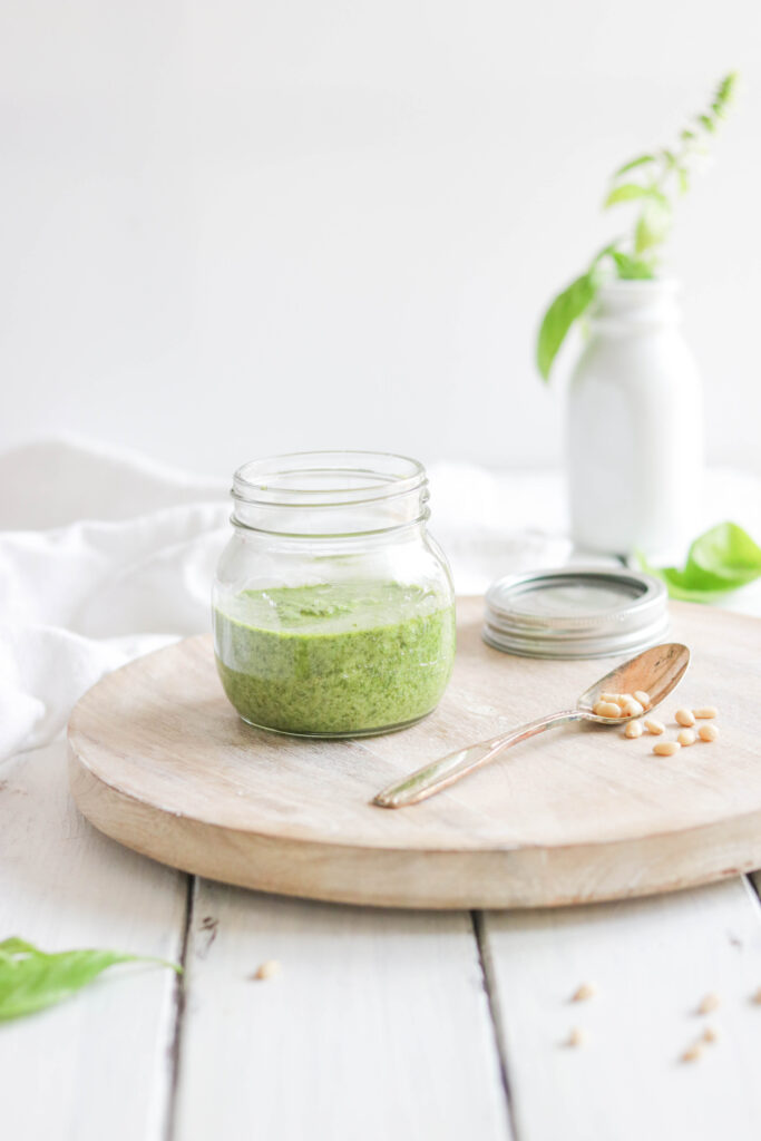 make easy pesto, green sauce, spoon with pine nuts, white food photography