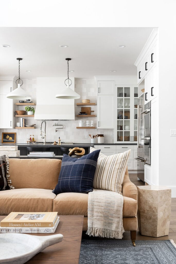 Studio Mcgee living room with beige couch, large black windows, warm tones, open living space