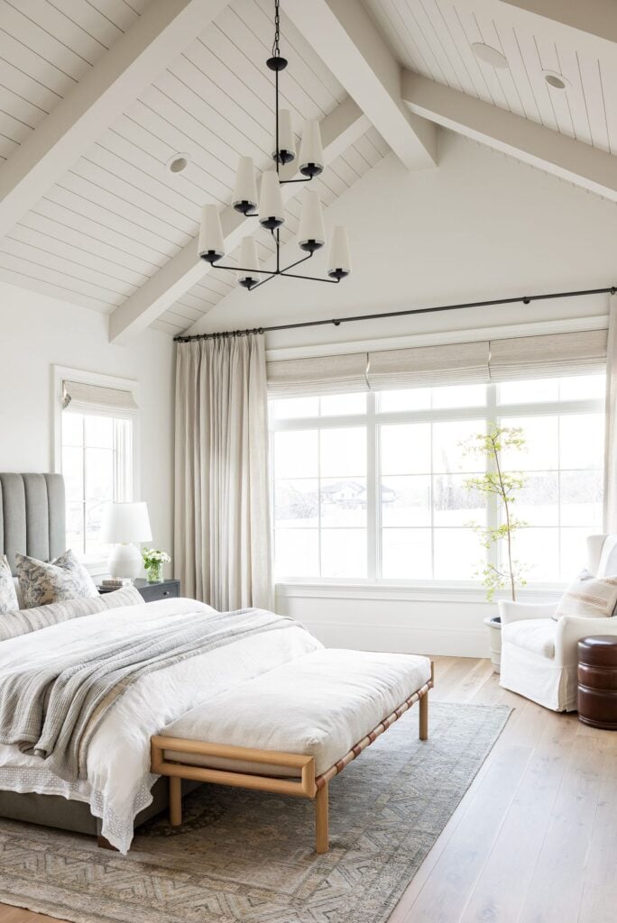 Studio McGee by Bedrooms: Studio McGee House; white walls, neutral colours, vaulted ceiling, large window, grey bed with white linen