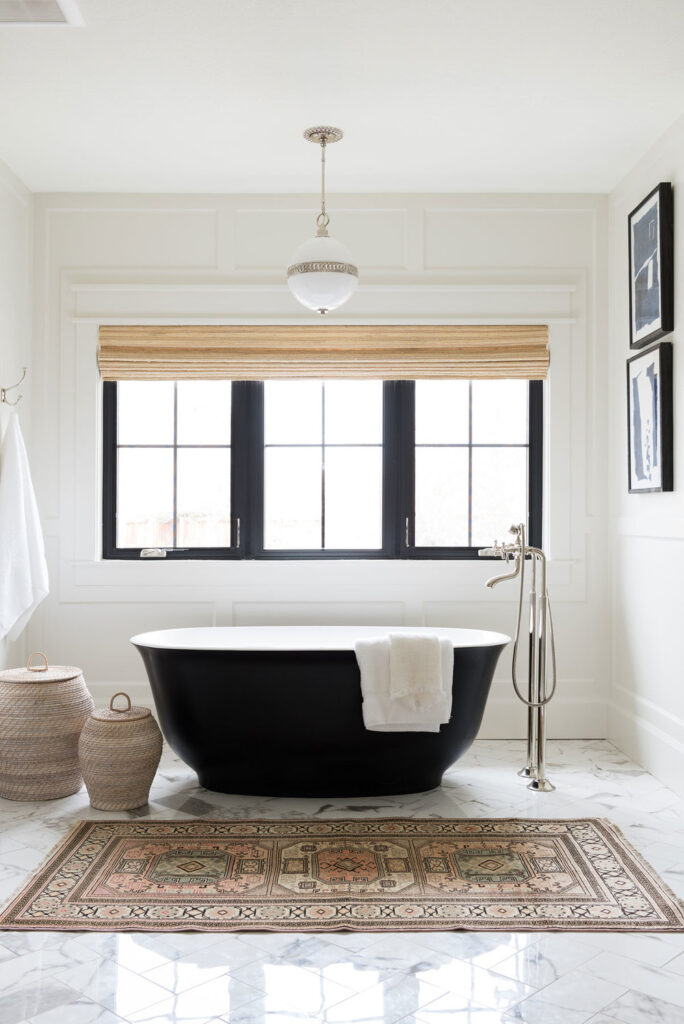 Bathrooms by Studio McGee; black tub, black stand alone bathtub, large window