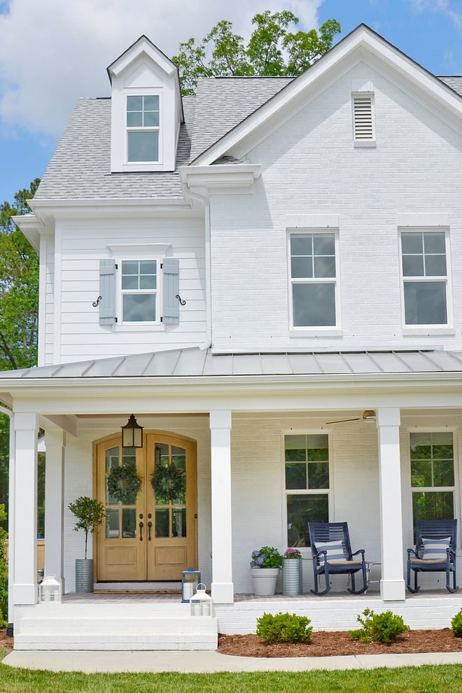 white modern farm house, white trim windows, large front porch, oak front door, porch rocking chairs