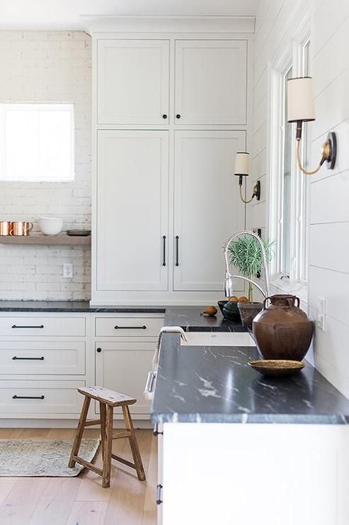 off white kitchen cabinets with dark soapstone countertops - 15 Beautiful Kitchens with Soapstone Countertops; Elegant and durable, soapstone is a favourite material for kitchen countertops. See 15 beautiful kitchens with soapstone countertops here.