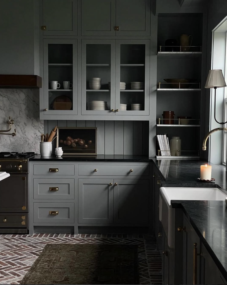 moody gray kitchen with soapstone countertops, brass hardware, and farmhouse sink