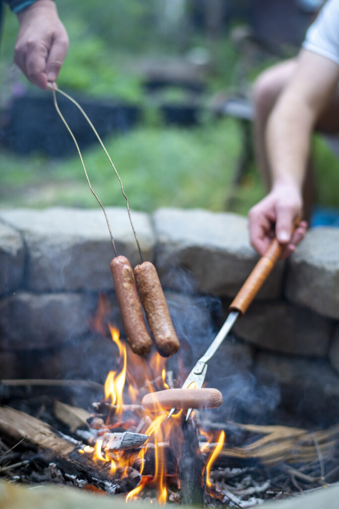 Hot dogs being roasted over a camp fire - 10 Easy Campfire Recipes (Be the Master of Campfire Cooking); Here are 10 campfire cooking recipes to try this summer!