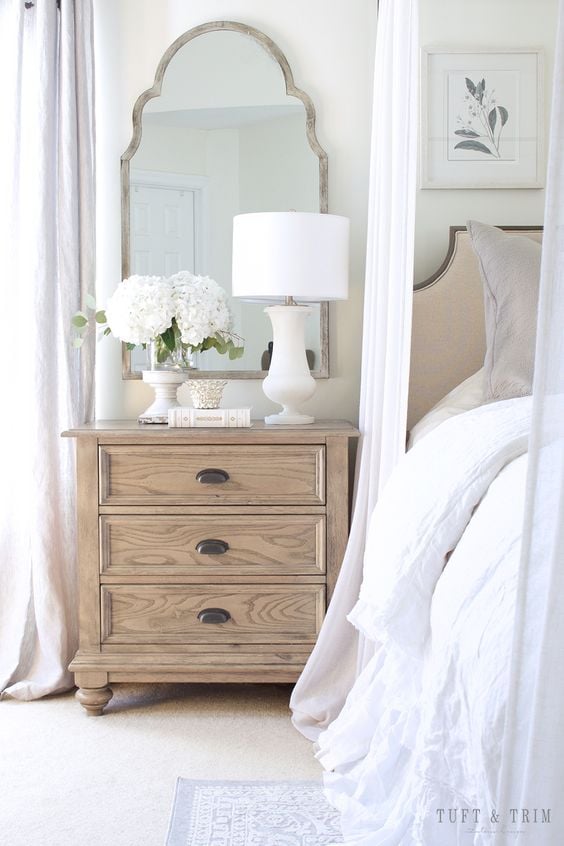 How to Decorate a Bedroom; bedside table, lamp, mirror above bedside table