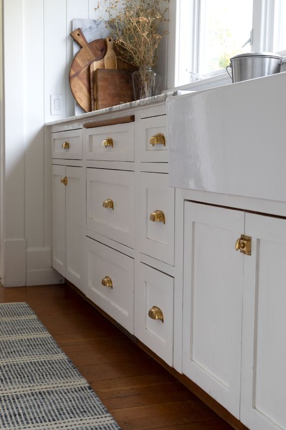 35 Beautiful White Kitchen Cabinets with Brass Hardware; Bring warmth to a bright kitchen design with these brass fixtures!