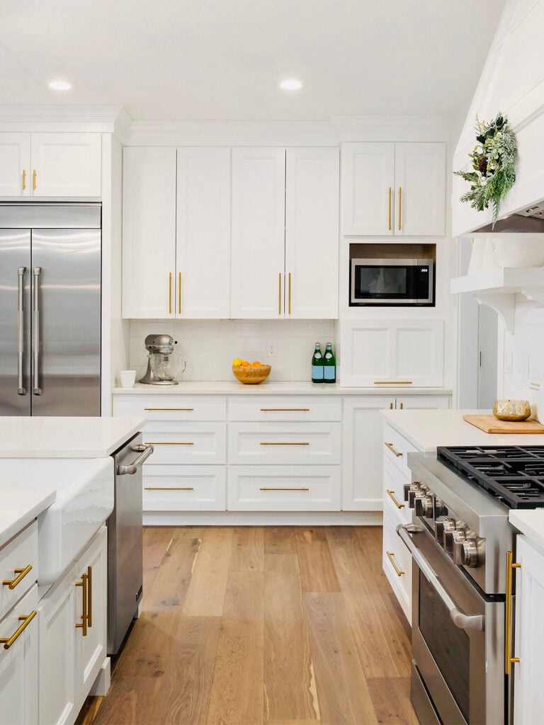 35 Beautiful White Kitchen Cabinets with Brass Hardware; Bring warmth to a bright kitchen design with these brass fixtures!