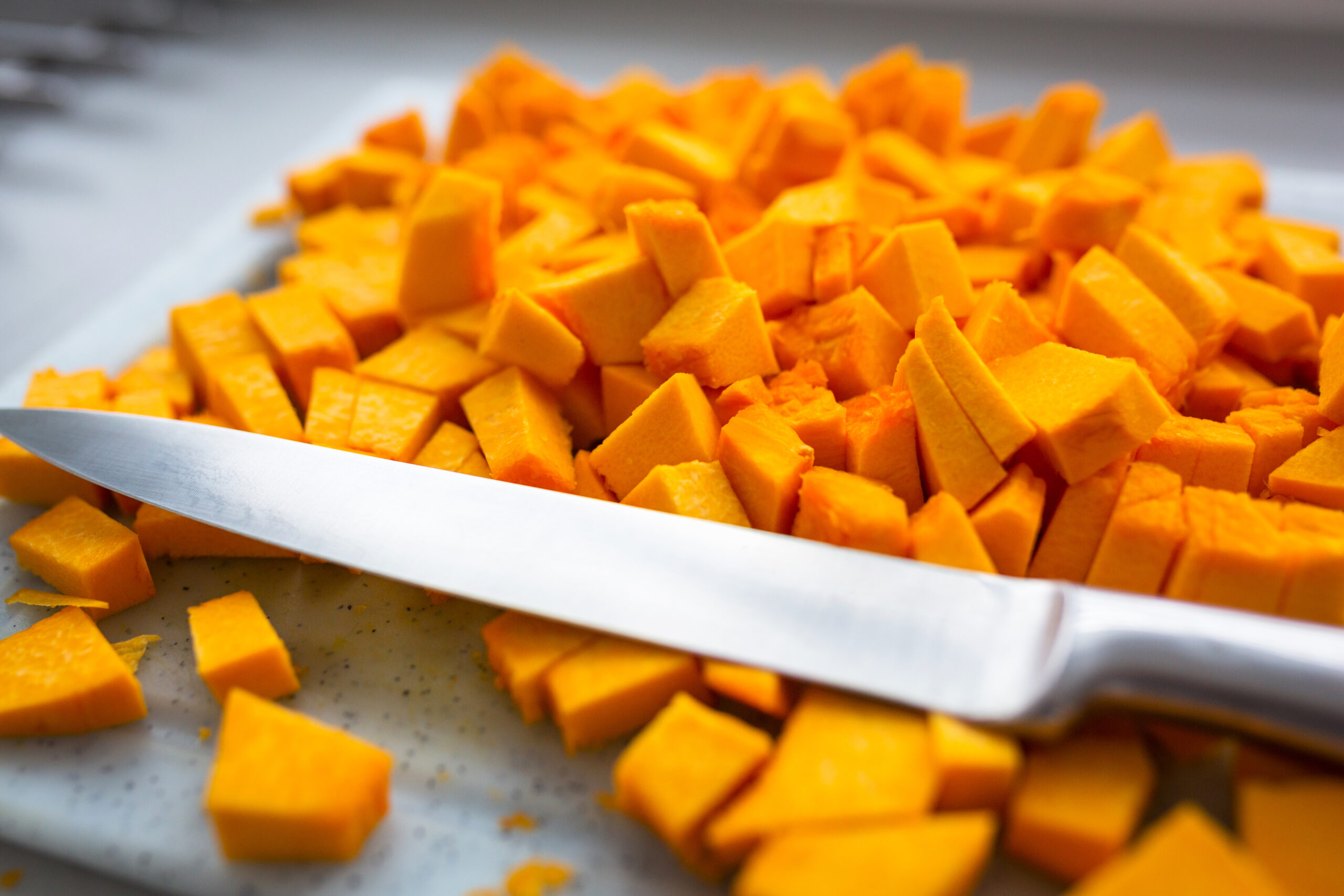 Squares of fresh pumpkin on the chopping board for cooking