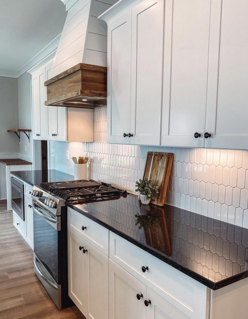 Farmhouse kitchen with black quartz countertops, white cabinets