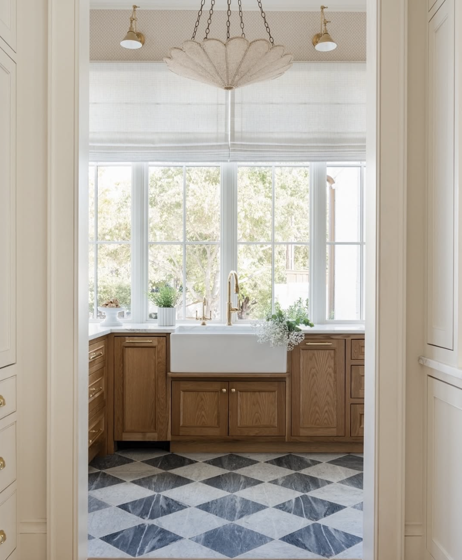 black and white checker tile flooring in bright farmhouse kitchen with wood cabinets