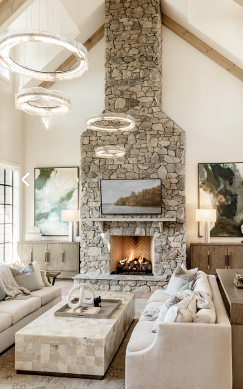 25 Most Beautiful Lake House Living Rooms ; Large beach style open concept light wood floor, brown floor and wood ceiling family room photo in Other with white walls, a standard fireplace, a stone fireplace and a wall-mounted tv -