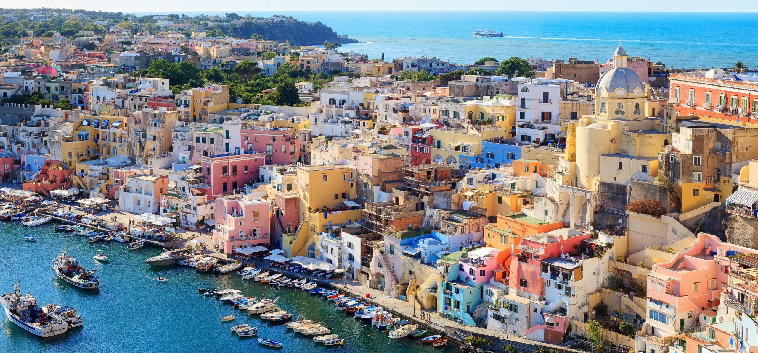 Naples: The Birthplace of Pizza - Panoramic view of the old village of fishermen's houses and the marina of Corricella, a classic panoramic view of the island of Procida, Italy.