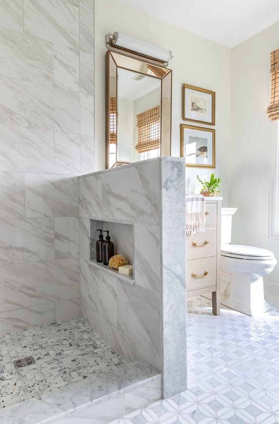 Bathroom tile trends for 2023 - bathroom renovation featuring marble mosaic tile, large format tile, warm wood vanity, polished nickel finishes, and vintage accents.