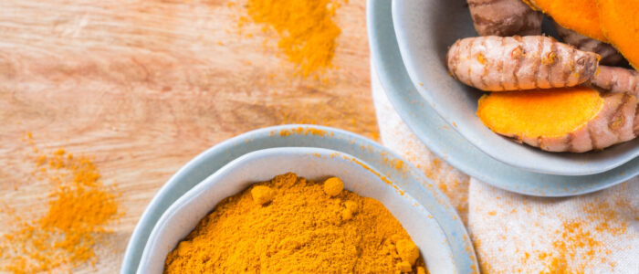 Benefits of Turmeric; Food and drink, diet nutrition, health care concept. Raw organic orange turmeric root and powder, curcuma longa on a cooking table. Indian oriental low cholesterol spices.