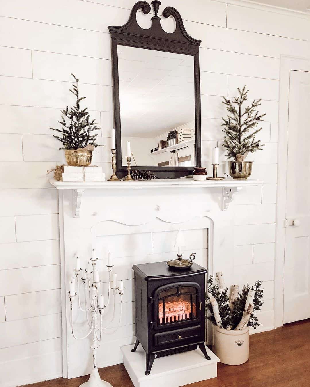 Mirror above fireplace ideas; Traditional rustic vibes come to life with the incorporation of an old-world inspired mirror above a cozy fireplace. The large rectangular mirror boasts a breathtaking Chippendale-style design, complete with a dark wood frame, intricate carvings, and a striking broken pediment top crowned with a central finial. The mirror's rustic charm evokes a sense of warmth and history, transporting viewers to a bygone era filled with tales of adventure and romance. Positioned above the fireplace, this striking mirror adds depth and character to the space, transforming it into a cozy nook that exudes timeless elegance and natural beauty.