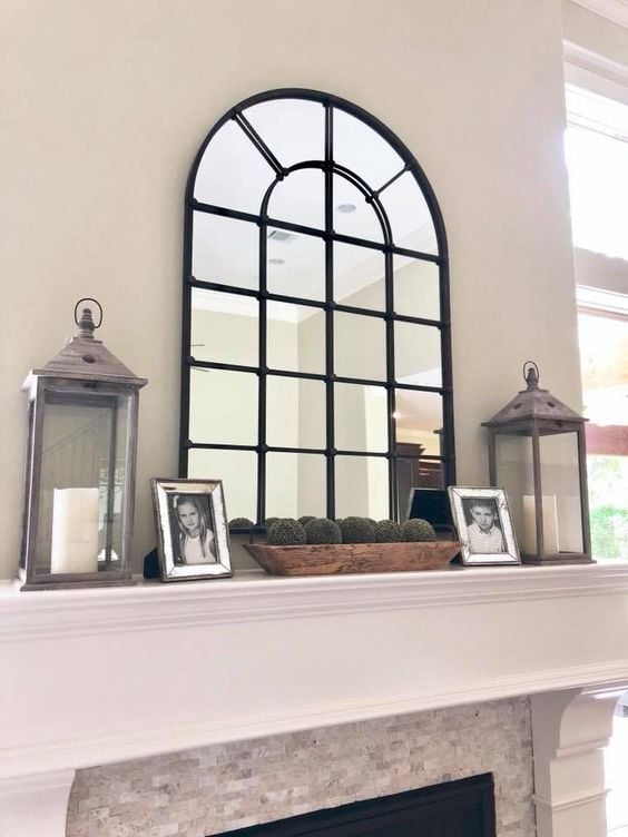 Mirror above fireplace ideas; This inviting photo showcases a charming black window pane mirror that has been placed on a mantle, instantly elevating the farmhouse vibes of the space. The mirror's rustic design and sleek black frame mimic the classic design of windowpanes, adding a touch of timeless elegance to the room. Its placement on the mantle creates a focal point that anchors the space and adds depth and warmth to the overall decor. And how cute are those photos!!