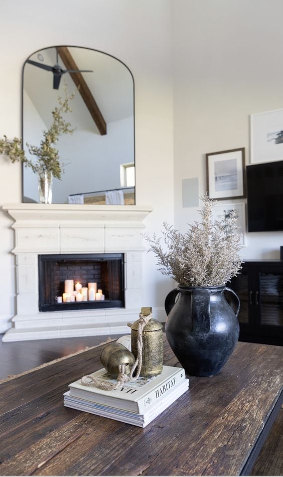 Mirror above fireplace ideas: extra tall mirror is placed above a fireplace in a bright and airy living room