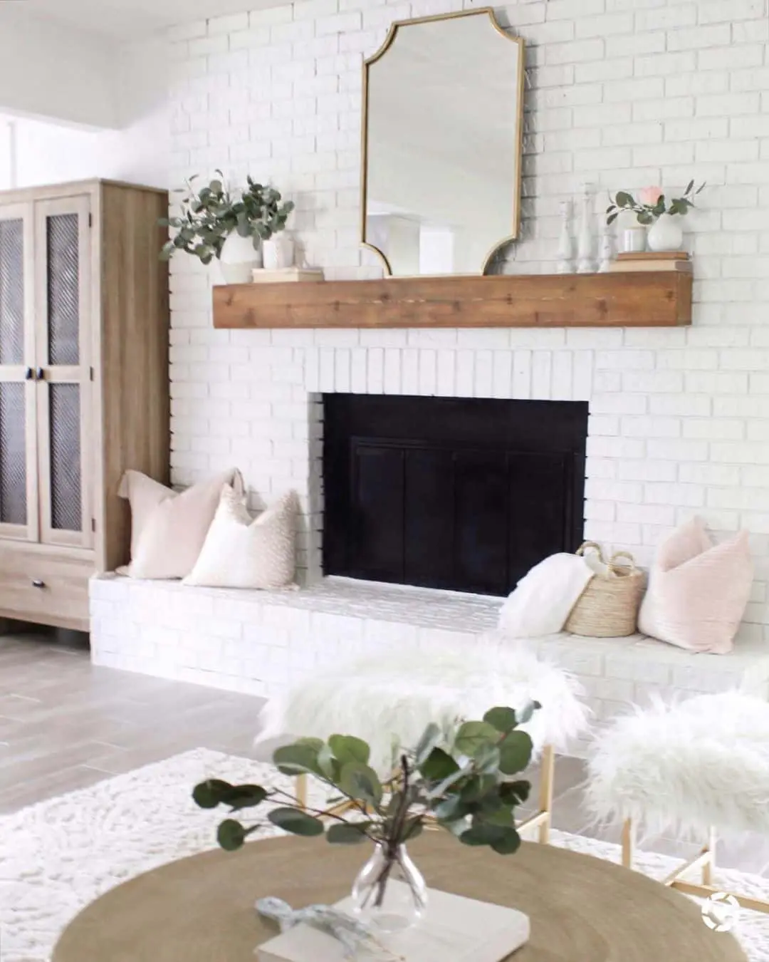 Mirror above fireplace ideas; Instead of opting for a rectangular mirror, consider choosing a large mirror with scalloped corners. This unique style serves as a perfect alternative and seamlessly complements cottage-style, transitional, and farmhouse interiors. The scalloped corners add a charming and distinctive touch, effortlessly blending in with the overall aesthetic of the space.