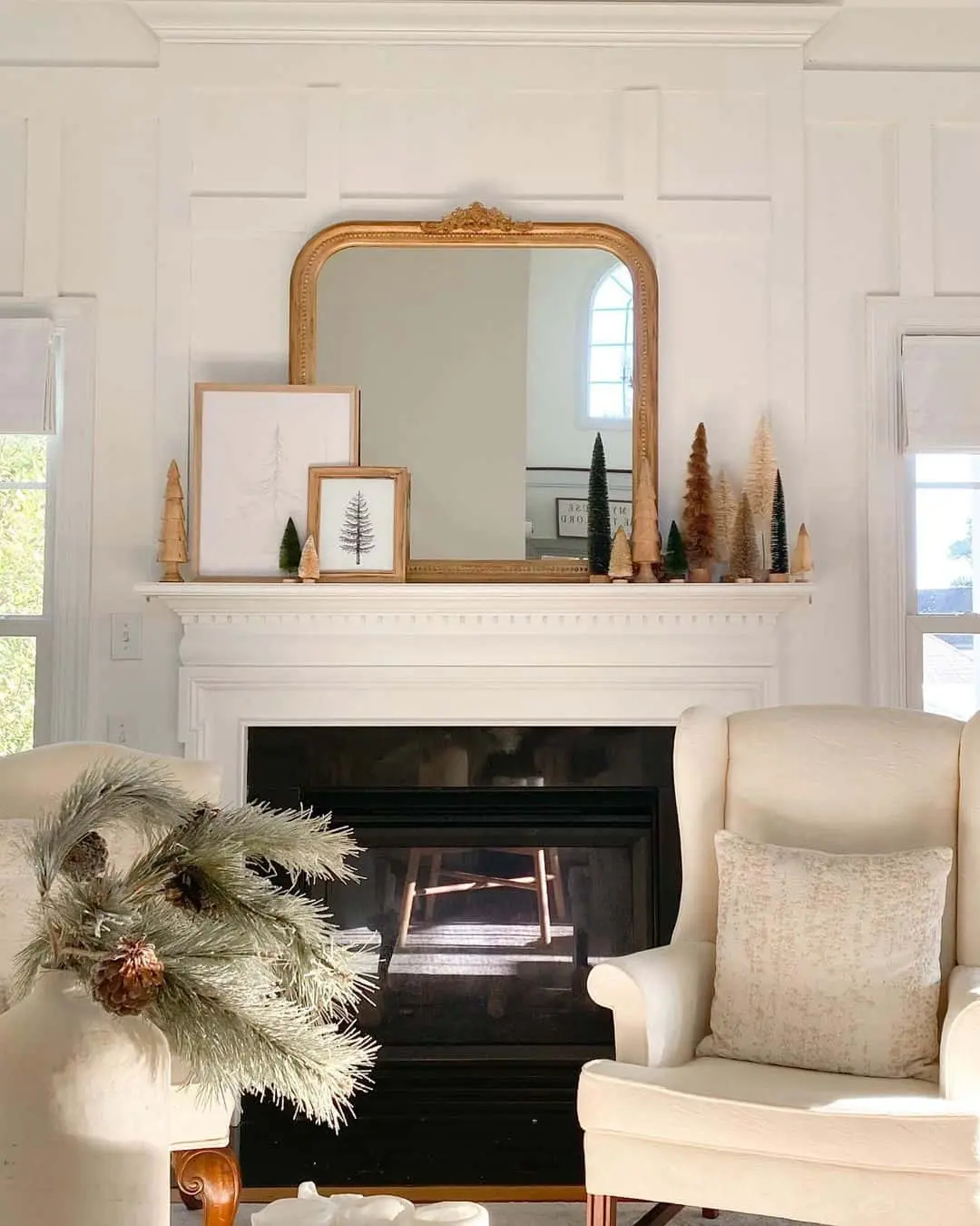Mirror above fireplace ideas; Step into a world of whimsy and romance with this delightful vignette. The floral painting, playfully layered in front of the stately vintage mirror, creates a captivating display that transports you to a dreamy garden. The intricate brass framing of both pieces not only adds a touch of sophistication but also creates a sense of unity and regality. It's as if the mirror and painting were destined to be together. To amp up the charm even more, brass candlesticks and fall florals are thoughtfully arranged around the vignette, adding a festive and warm touch.
