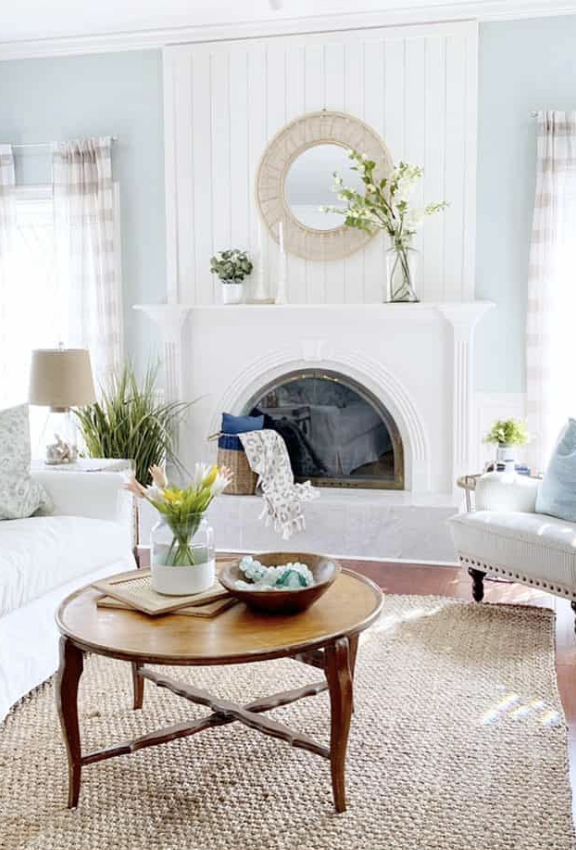Mirror above fireplace ideas; A stylish wicker-style mirror positioned above a fireplace instantly becomes the focal point of the room. The intricate wicker detailing adds a touch of natural texture and warmth to the space, creating a cozy and inviting atmosphere. The mirror's placement above the fireplace enhances the room's visual appeal, combining functionality with aesthetic charm.