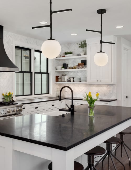 White Cabinets With Stone Backsplash and Black Countertops