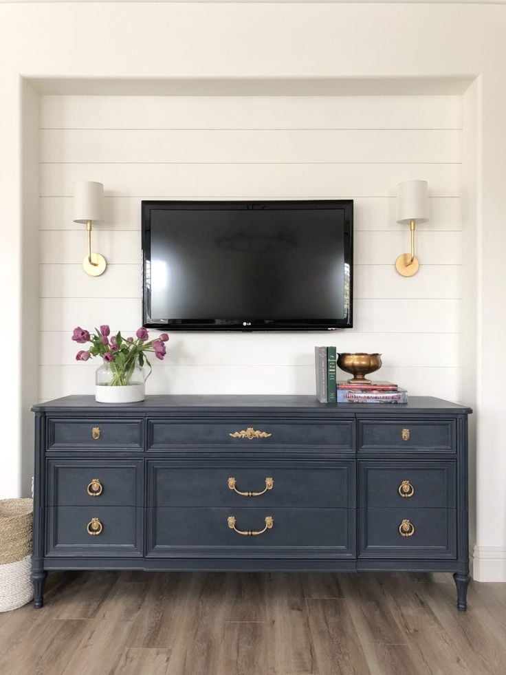 farmhouse TV stand ideas; A farmhouse gray antique dresser turned TV stand, is a perfect piece to add vintage charm to your living space. The gray antique finish adds a weathered yet classic look, evoking a sense of rustic elegance. With its spacious drawers and sturdy construction, this dresser TV stand provides ample storage space while serving as a stylish and functional addition to any home.