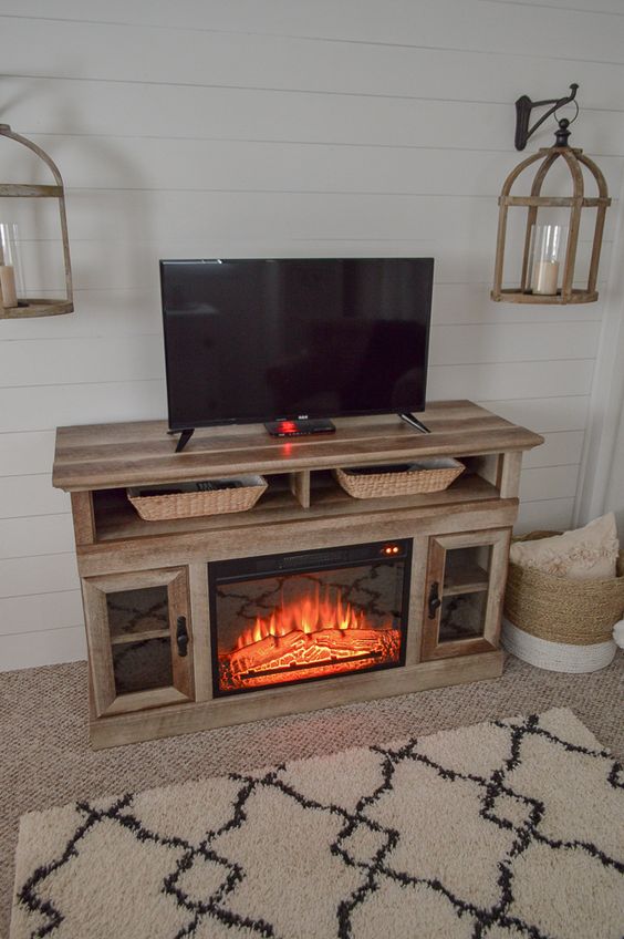 farmhouse TV stand ideas; Capture the essence of farmhouse charm with this TV cabinet equipped with cozy electric fireplace units. The combination of rustic design and the soothing warmth of the fireplace creates a cozy and inviting atmosphere in any space. Experience the perfect blend of style and comfort with this delightful addition to your home.