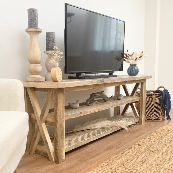 farmhouse TV stand ideas; A solid reclaimed wood TV unit with open shelving, a perfect blend of sustainability and craftsmanship. The unit is made from reclaimed wood, showcasing its unique character and history. With its solid construction, it provides sturdy support for your television and media devices. The open shelving design offers a stylish and practical solution for storing and displaying your favorite books, DVDs, and decor while adding a rustic touch to your living space.