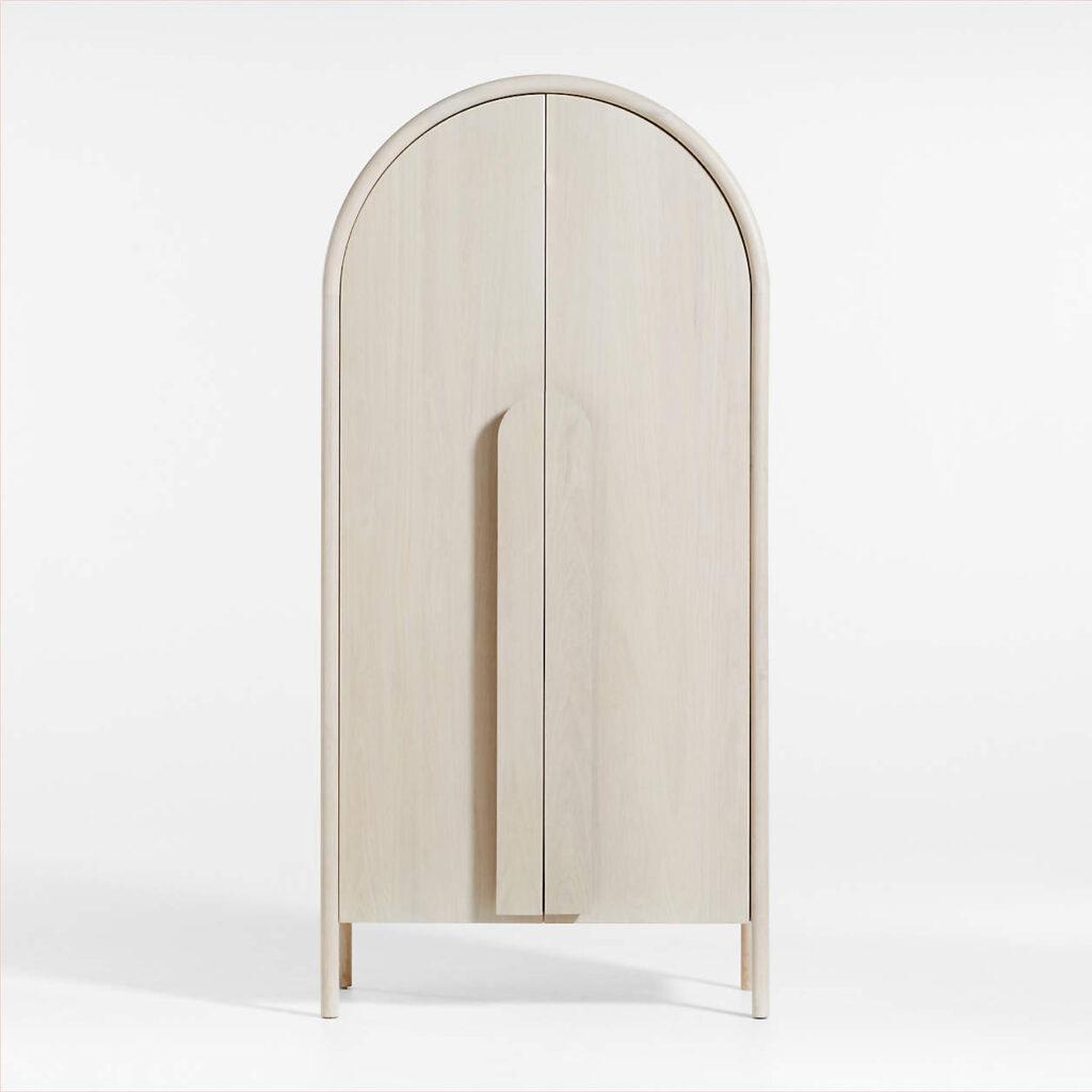 This contemporary take on the traditional curio cabinet artfully incorporates slender bentwood poles that create a perfect arch, elegantly highlighting the white oak featured on the large, flat-front doors. With its modish, clean-lined look, the Annie Whitewash Storage Cabinet not only serves your storage needs but also elevates your space's decor to a whole new level.