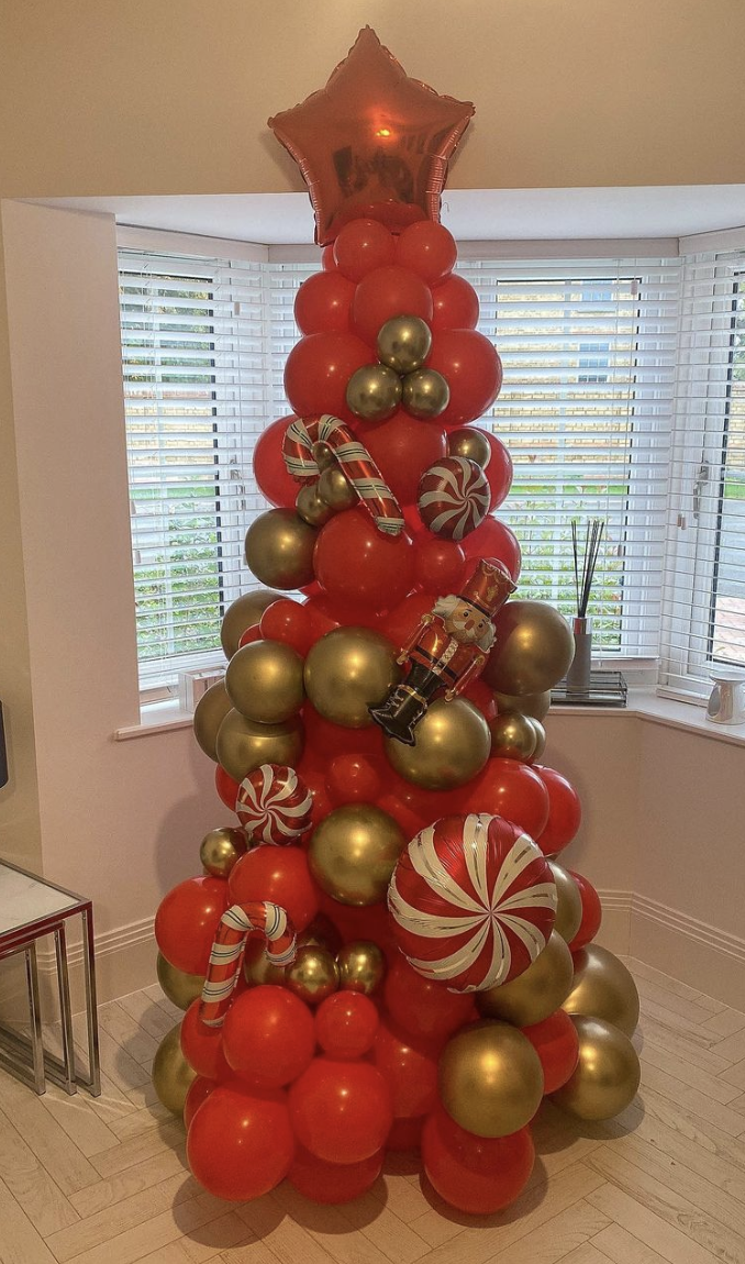 25 Balloon Christmas Tree Ideas: A vibrant and creative balloon Christmas tree constructed from various sizes of balloons arranged in a classic tree shape, with colorful mini balloon ornaments. The tree gives a festive and unique twist to traditional holiday decor.