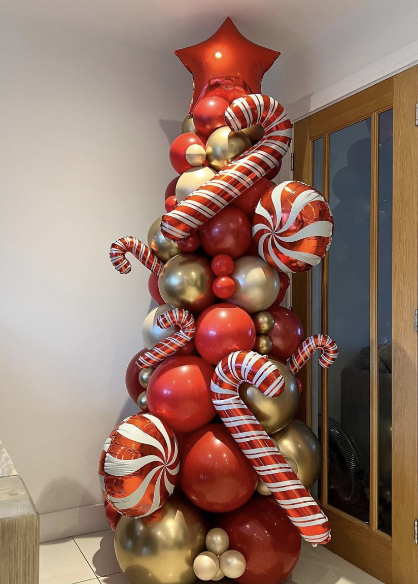 25 Balloon Christmas Tree Ideas: A vibrant and creative balloon Christmas tree constructed from various sizes of balloons arranged in a classic tree shape, with colorful mini balloon ornaments. The tree gives a festive and unique twist to traditional holiday decor.