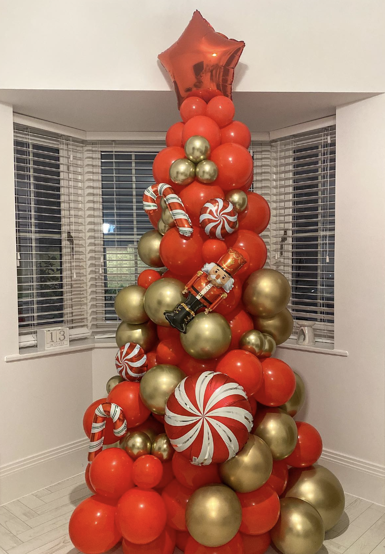 25 Balloon Christmas Tree Ideas: A vibrant and creative balloon Christmas tree constructed from various sizes of balloons arranged in a classic tree shape, with colorful mini balloon ornaments. The tree gives a festive and unique twist to traditional holiday decor.