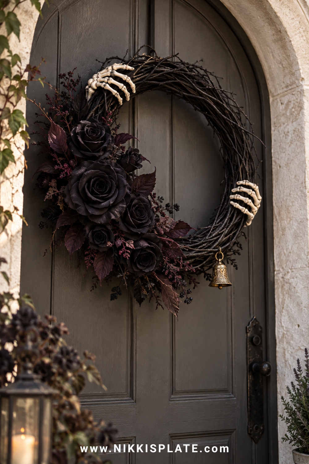 Black rose Halloween wreath held by two small skeleton hands