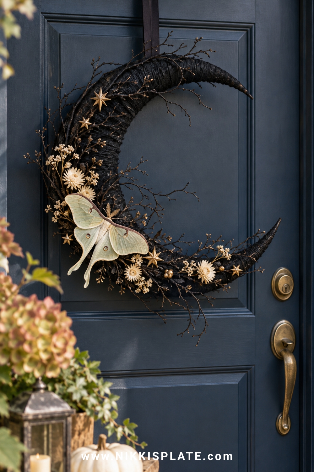 Black crescent moon wreath with a pale moth, dried flowers and tiny stars