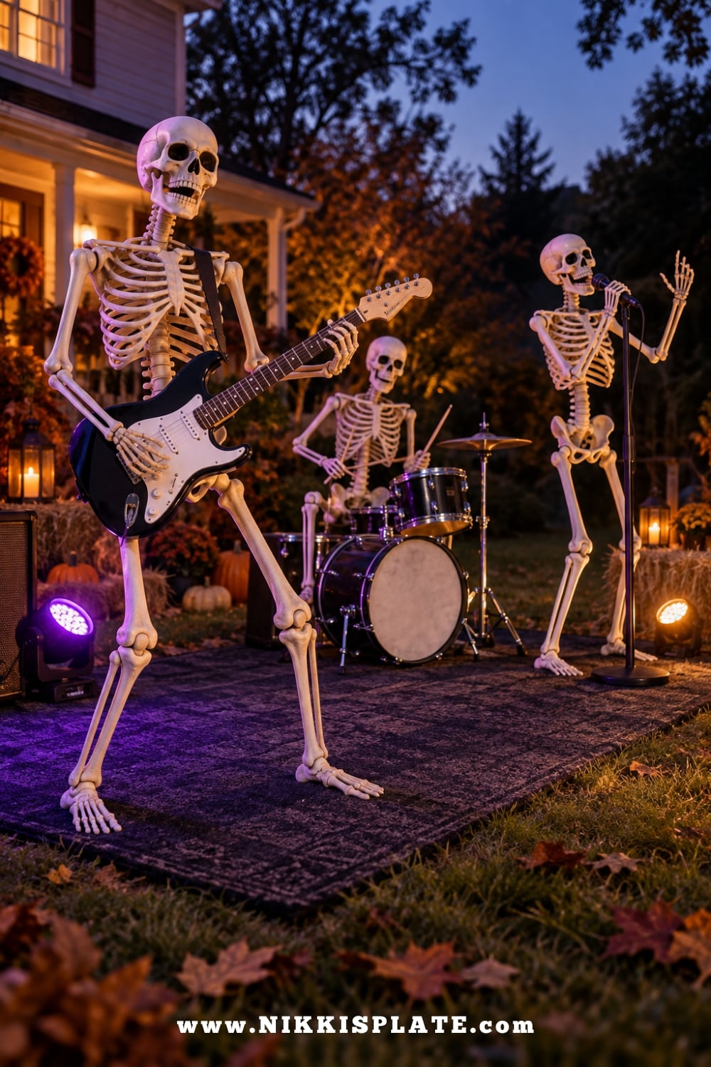 Three skeletons performing with a toy guitar, drum set and microphone in a Halloween yard