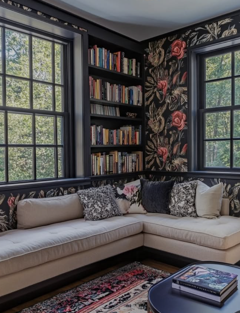 Dark floral wallpaper reading nook with built-in bookshelves and neutral sectional seating