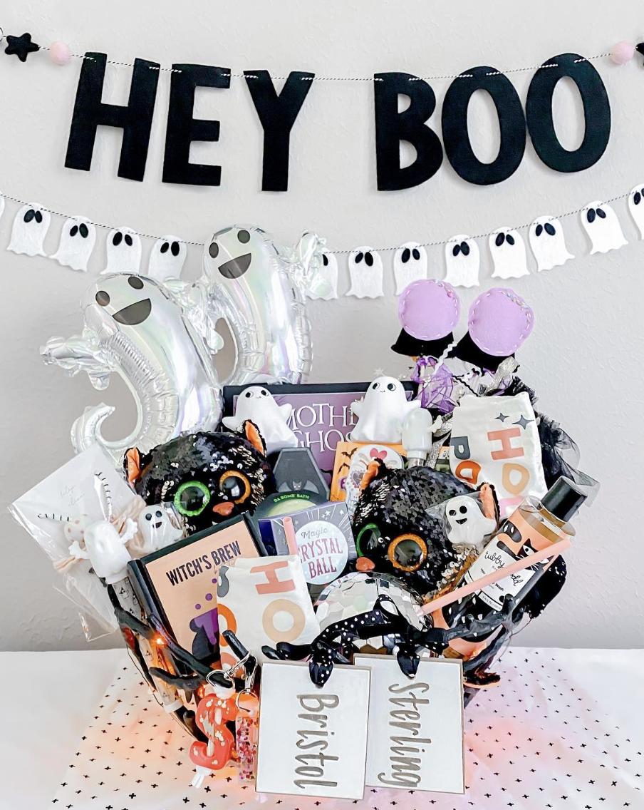 Deluxe Halloween boo basket for kids with black cats, ghost plushies, books, treats, and personalized name tags for Bristol and Sterling.