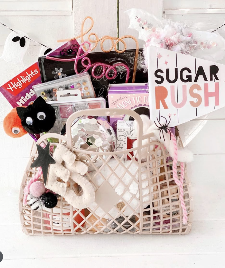 Sugar Rush-themed boo basket for girls filled with crafts, pom-pom toys, candy, a disco ball, and pink Halloween accessories.