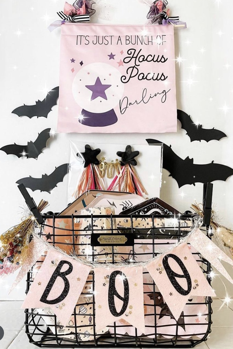 Pink and black glam-themed boo basket for kids with Hocus Pocus sign, sparkle wands, Halloween accessories, and soft pastel tones.