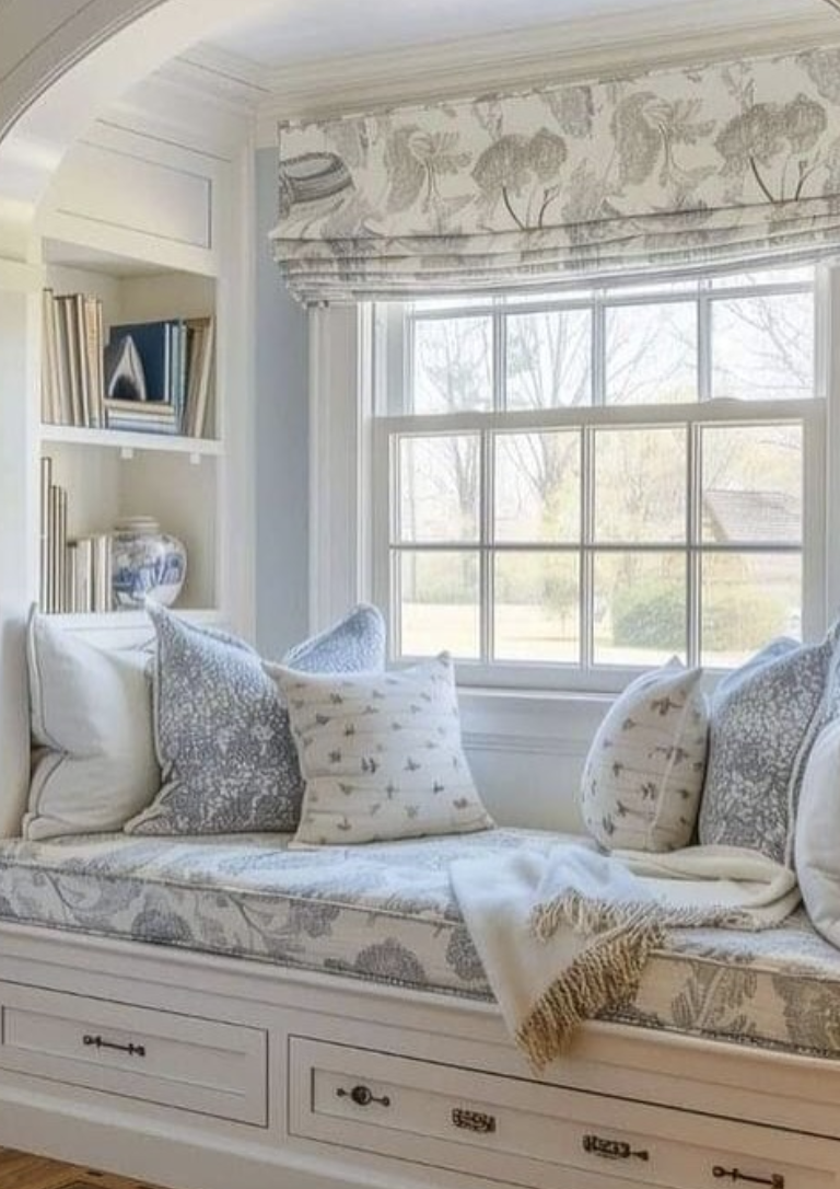 White reading nook with floral cushions, built-in bench, and soft natural light
