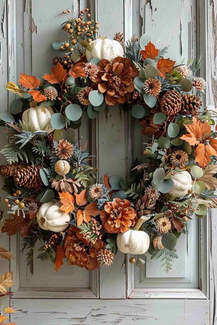 Dried flower autumn wreath hanging on a wooden door in a grandmacore-inspired entryway.