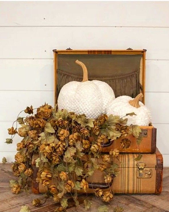 Vintage suitcases stacked and topped with white pumpkin and dried florals for a cozy fall grandmacore look.