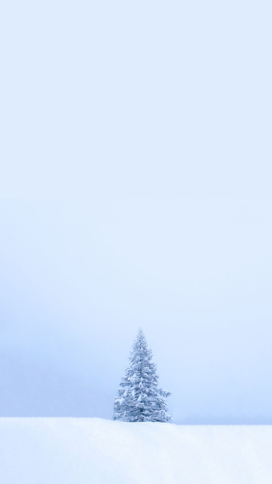 Minimalist winter wallpaper featuring a single snow-covered tree in the snow