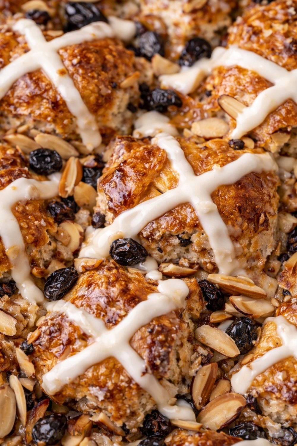 Close-up of golden hot cross bun French toast casserole with icing and sliced almonds