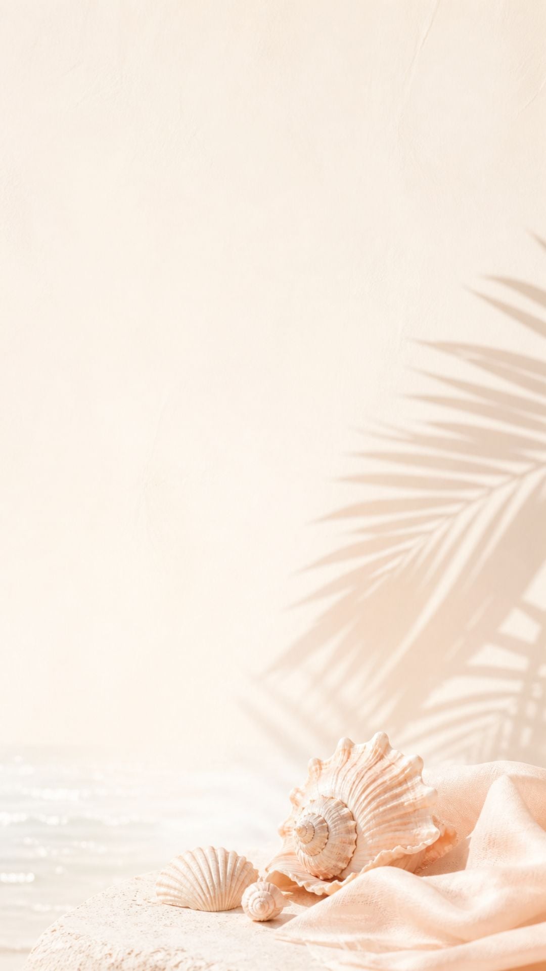 Minimalist summer iPhone wallpaper with soft seashells, blush fabric, palm shadow, and neutral beach tones